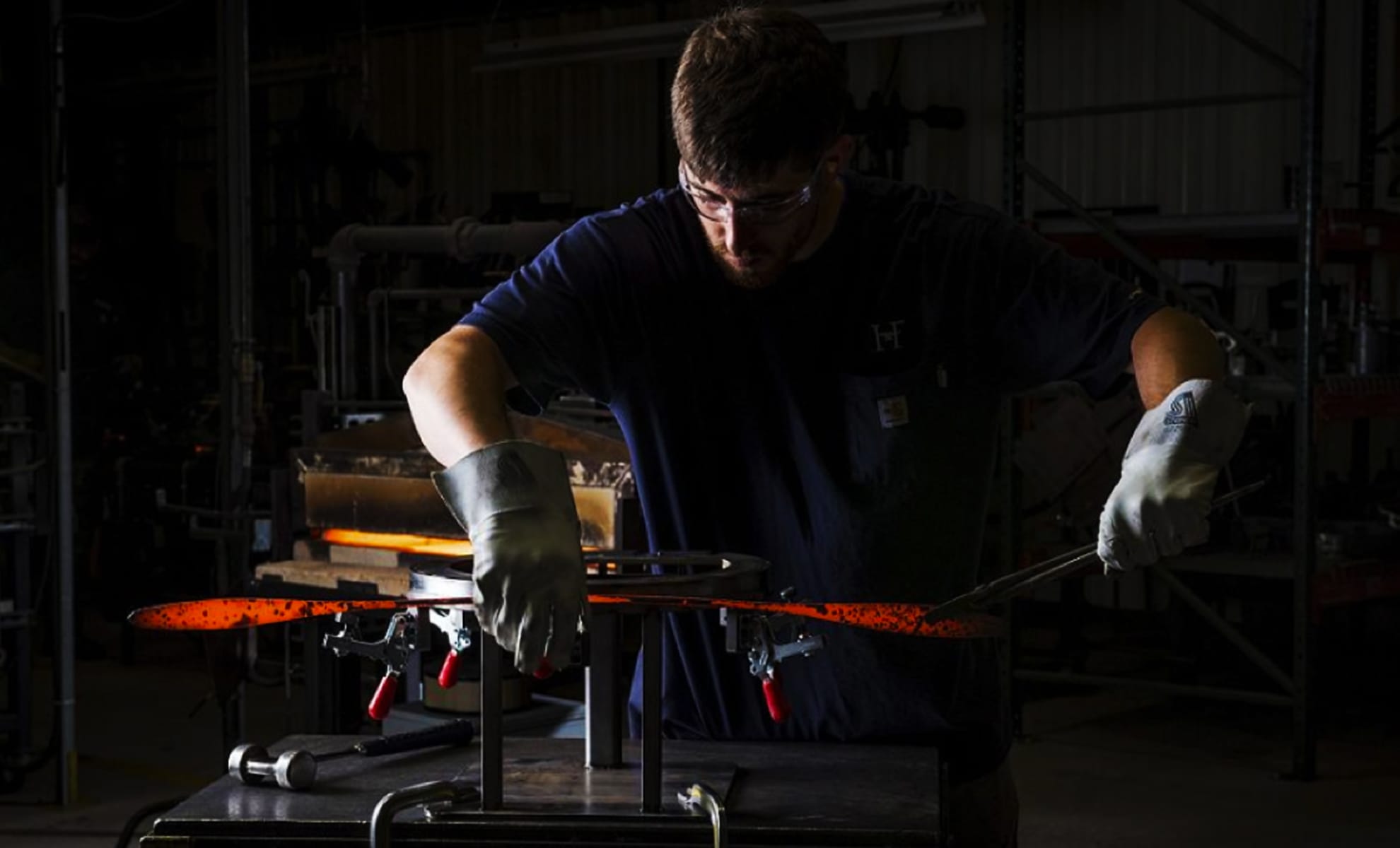 A craftsman for forges “petals” for the Dahlia Chandelier.